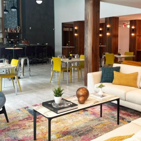 a clubroom with a couch, tables and chairs